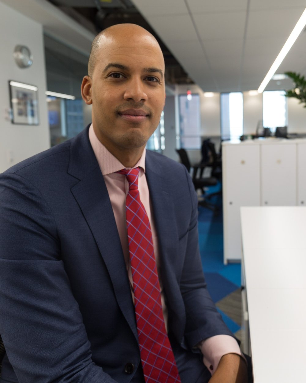 Ryan Overton in a navy suit, seated at a desk